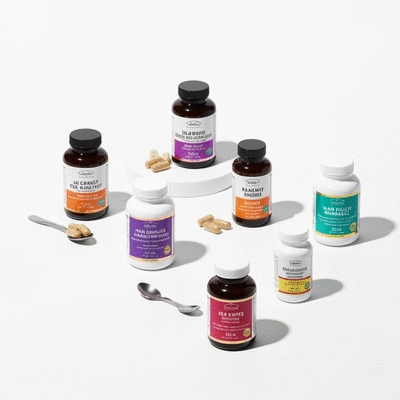 Assortment of hair health supplements and pharmaceutical hair loss medications on a clean white background